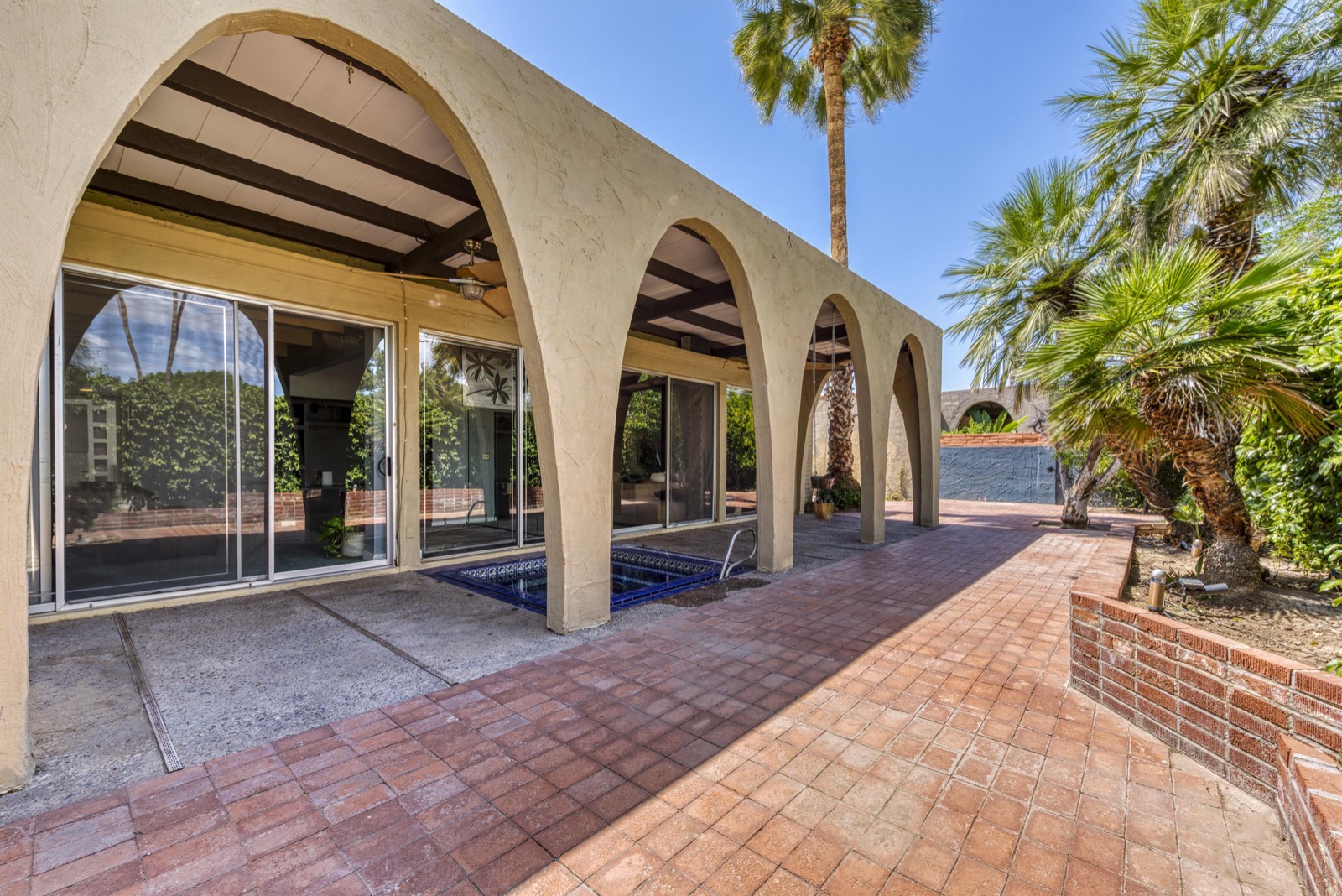 Covered patio with arched columns and sliding glass doors at 1542 E Solano Dr, Phoenix